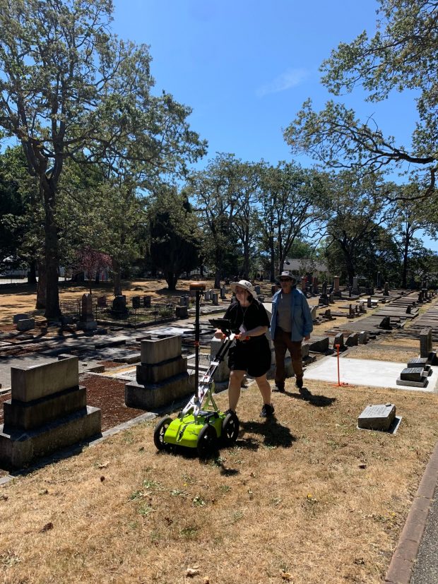 Sky pushes the GPR unit along an empty row in the cemetery.