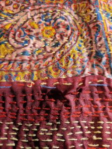 fabric with red, pink, and gold stitching