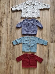 four baby sweaters