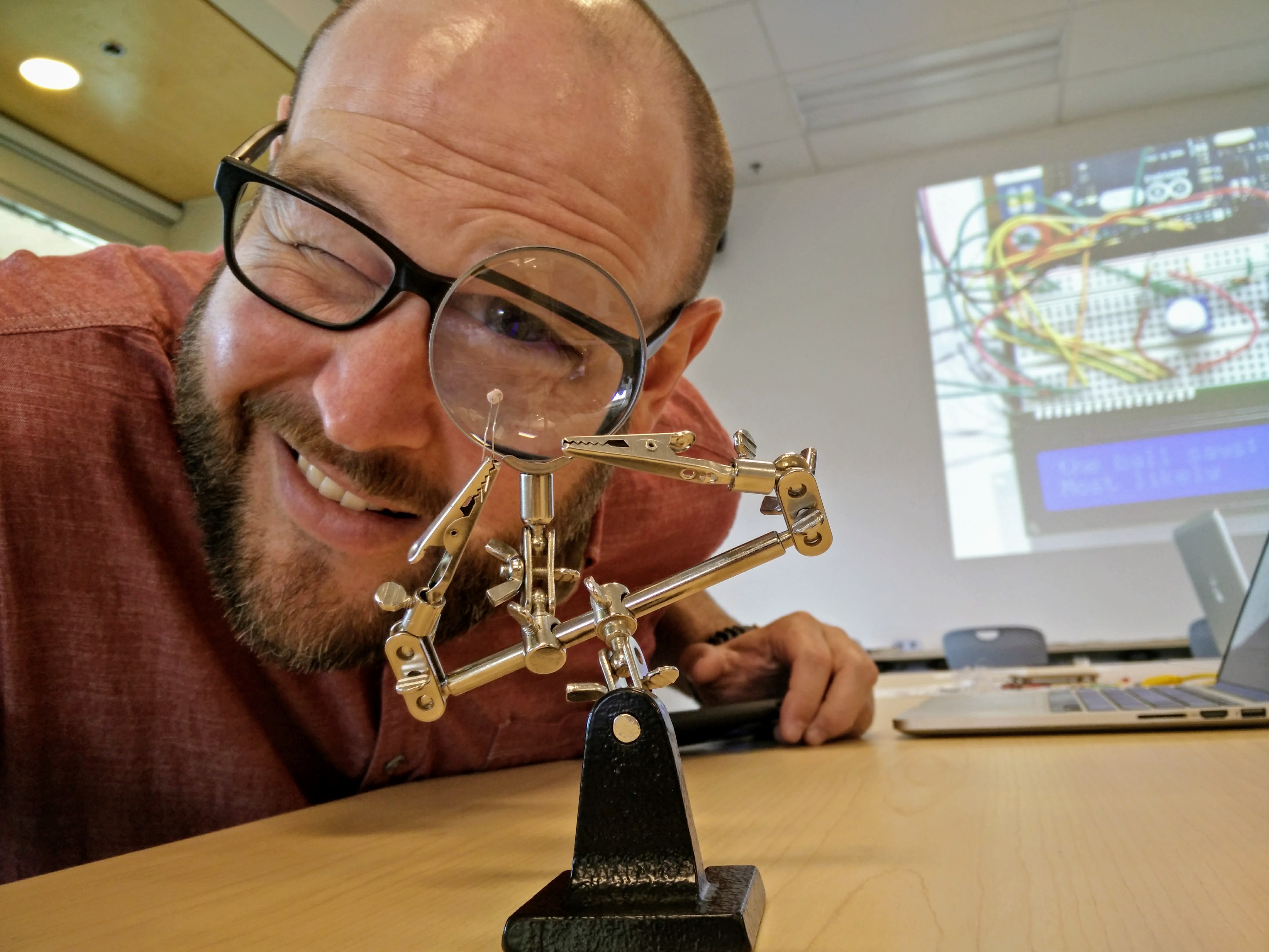 Dr. J. Matthew Huculak looking through a magnifying glass