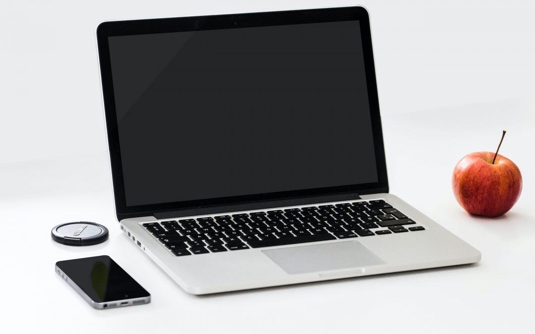 Photo of laptop with smartphone and apple