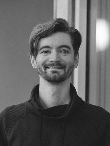 Profile photo of Nathaniel Loman, standing in front of the windows in the hallway of the DSC