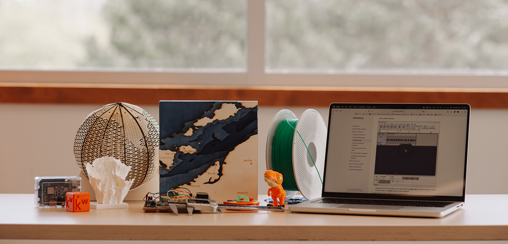 Photo taken in the DSC of various 3D printed and laser cut objects and a laptop on a table