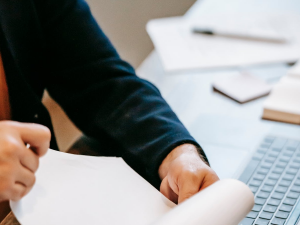 Hands holding a blank piece of paper.