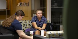 This photo shows two students in the library at Fraser building, drinking coffee and studying.