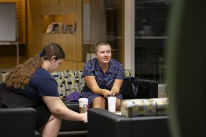 This photo shows two students in the library at Fraser building, drinking coffee and studying.