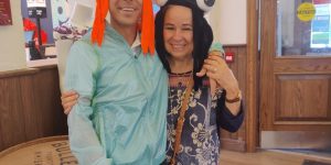 The photo shows OG with his mom, and both are wearing very silly hats and smiling.