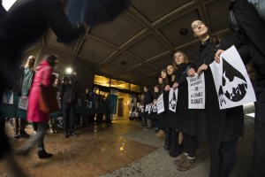 Members of the UVic Board of Governors walk through a 'human corridor' of students, demanding the University choose between fossil fuel investments and climate solutions.