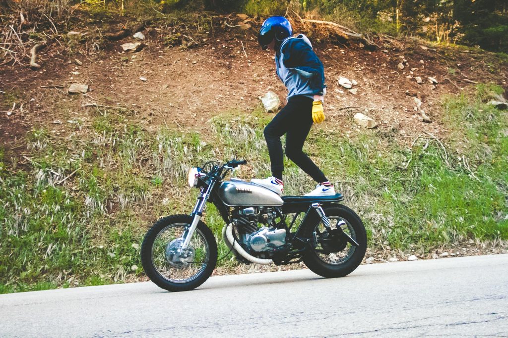 man standing on motorbike