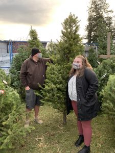 Man and woman shopping for Christmas trees