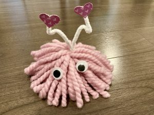 A valentines' day craft called a lovebug due to it's similarity to a bug using a ball of pink yarn with googly eyes for the face and pipe cleaner antennae with hearts at the top of the antennae.