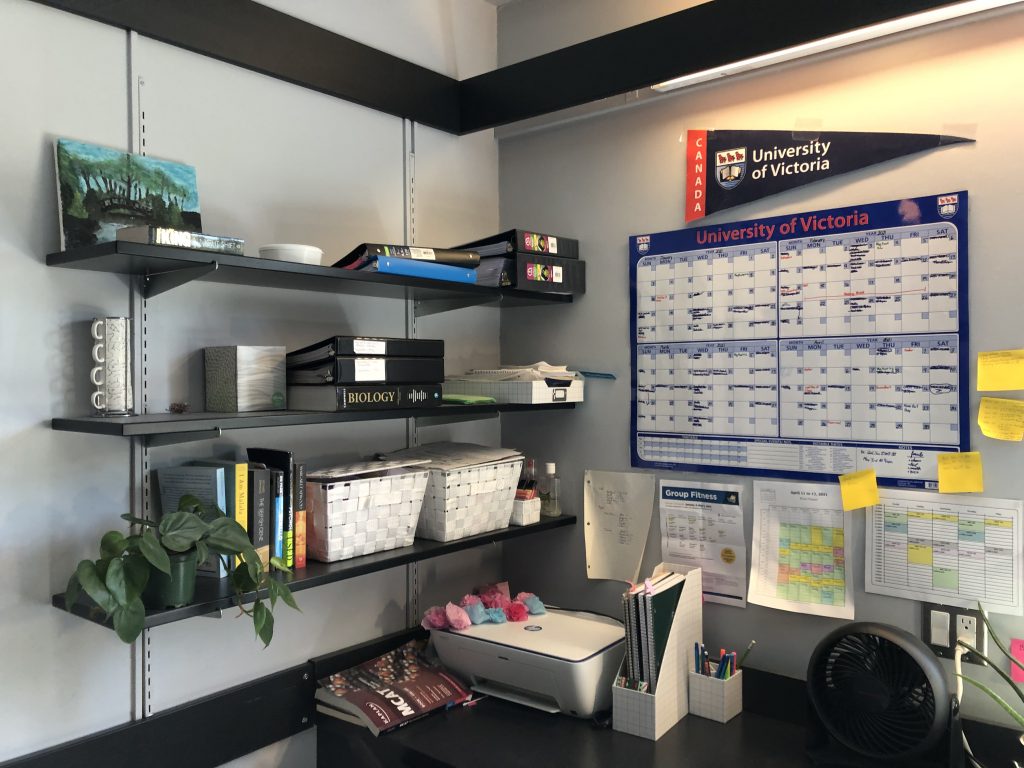 student desk with calendar and sticky notes on wall