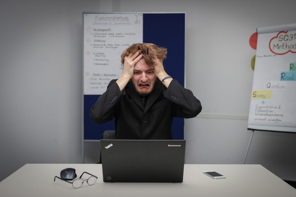 man with head in hands looking stressed