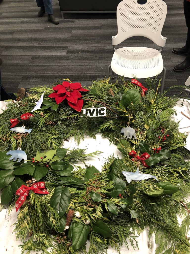 A wreathe made by students with decorations including a Uvic ornament, and flowers.