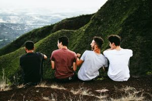 4 men sitting on mountainside