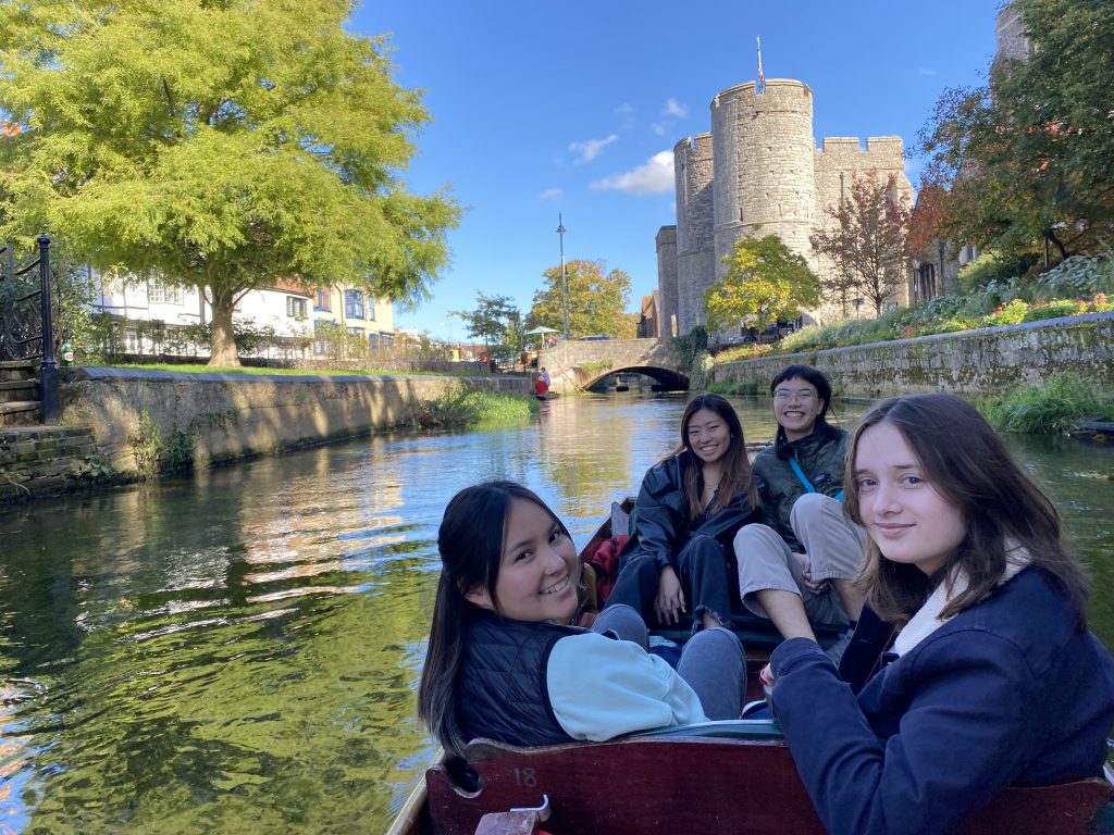 women in boat with castle in background