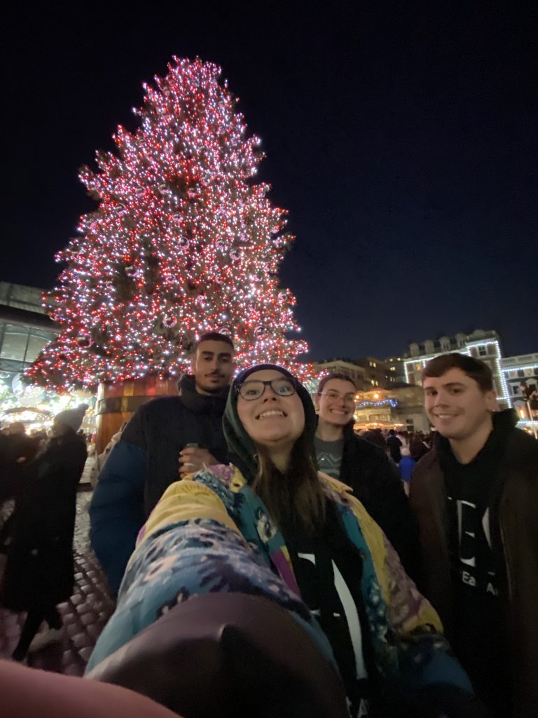 students in front of tree with lights