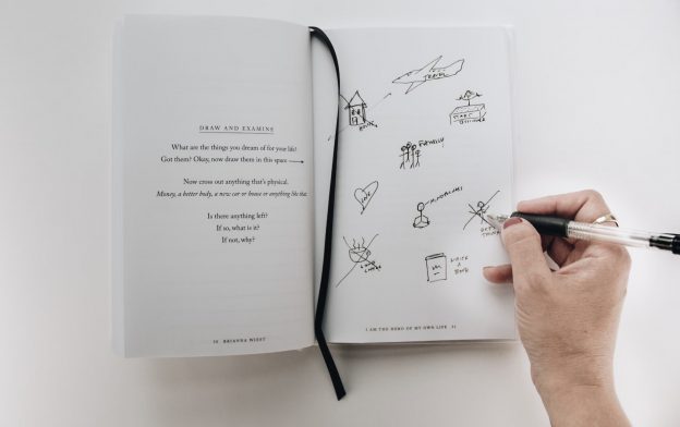 A young woman writing in a notebook, symbolizing reflection and growth.