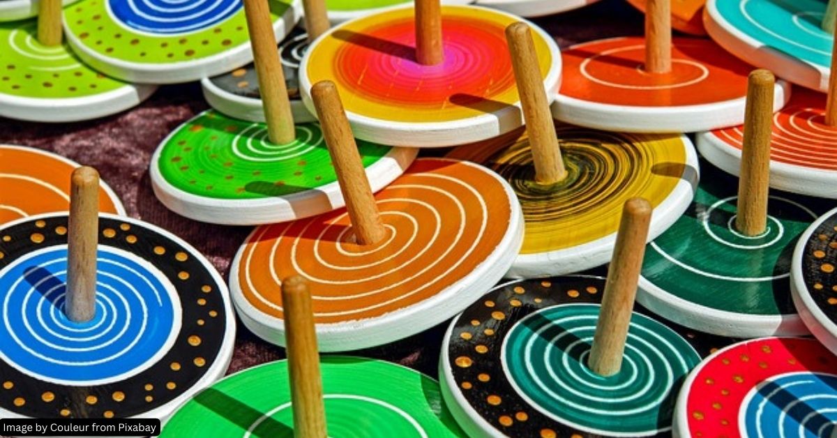 About ten colorful wooden spinning tops