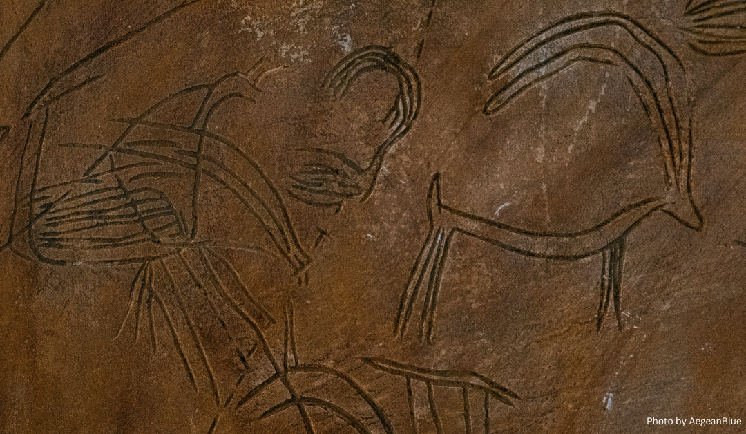 An image of Paleolithic rock art depicting stylized and simplistic human figures and animals etched into a brown stone surface.