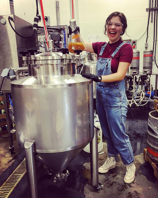 student next to brewing tank