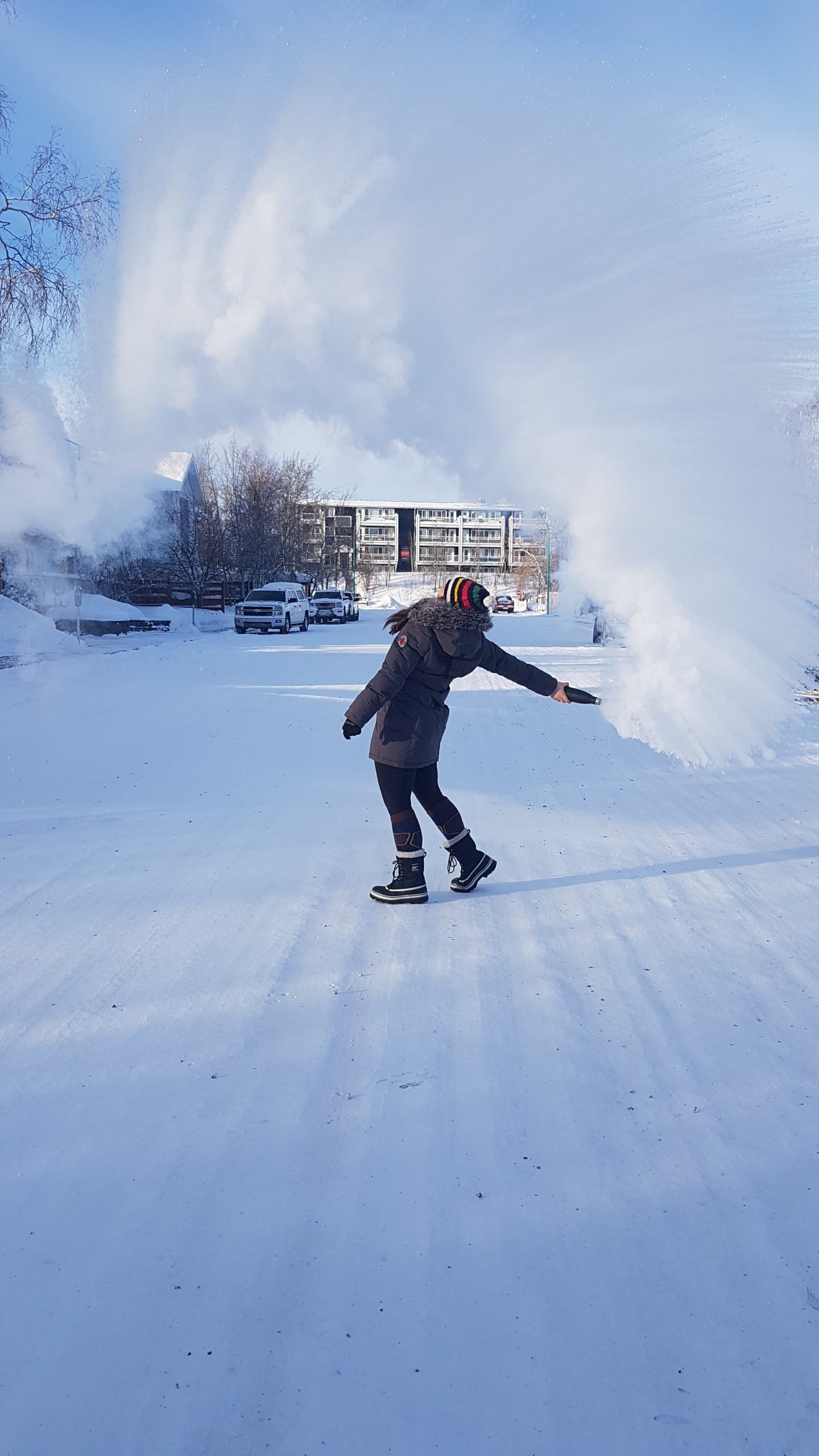 student in snow throwing boiling water in the air