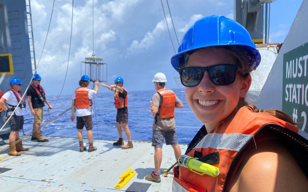 student wearing hard hat and life vest onboard a research vessel