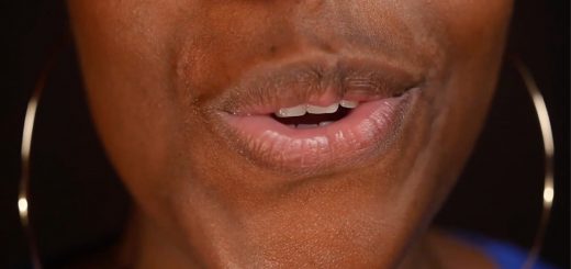Close up of a woman's mouth speaking to the camera.