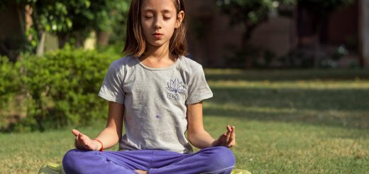 Young girl meditating on lawn