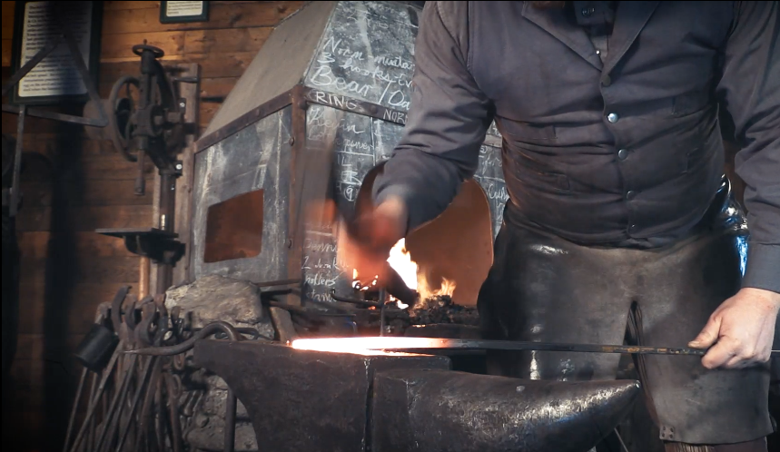 Blacksmith hammering on anvil