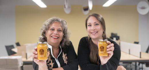 Switlos smile at the camera holding jars of turmeric paste
