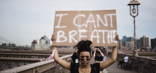 Woman holds a sign saying 'I can't breathe'