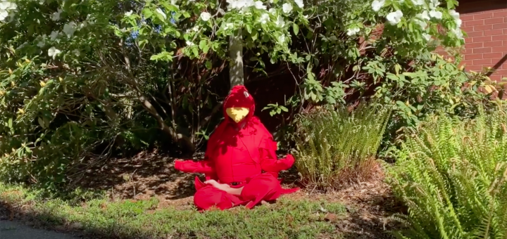 Woman in red martlet costume sits meditating