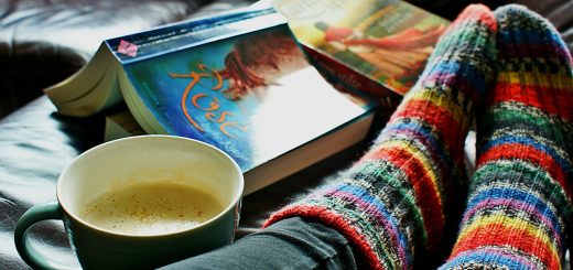 image of book, cup of coffee and feet in comfy socks