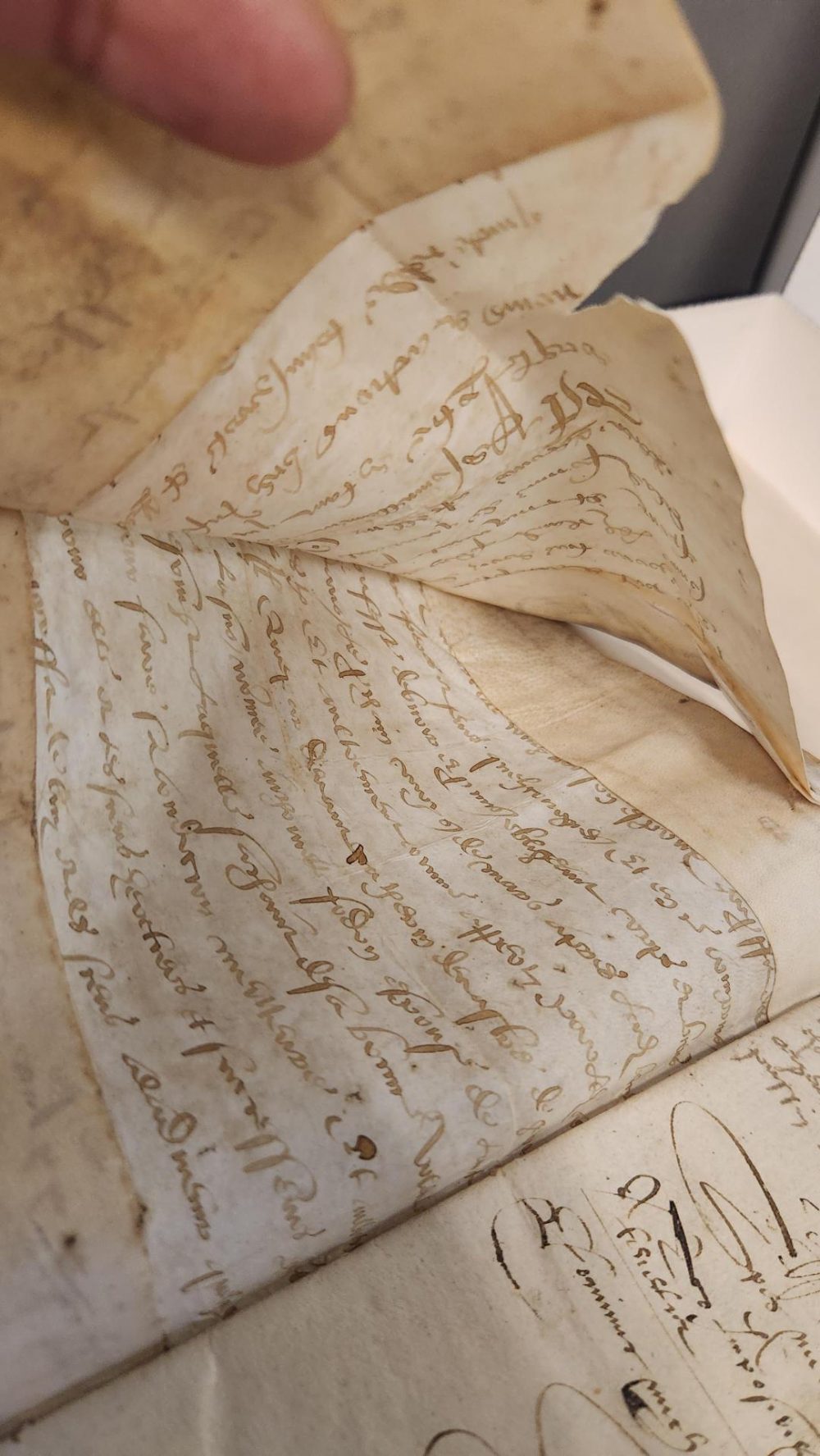 image of a folded over scrap manuscript being held open 