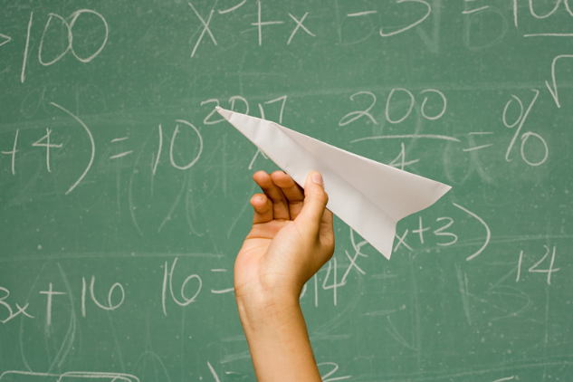 A hand holding a paper airplane.