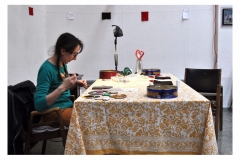 Artist Teresa Vander Meer-Chassé beading at table.